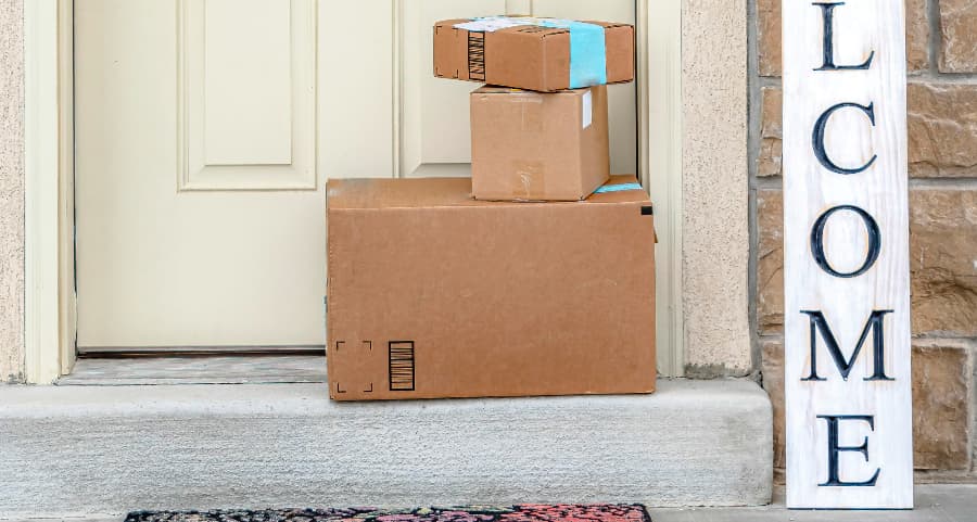 Boxes by the door of a residence with a welcome sign in Flint